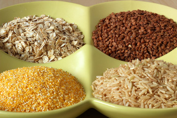 Variety of healthy grains and seeds in bowl: buckwheat, oatmeal,
