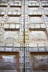Detail of an old wooden doorway with metal nails reinforcement