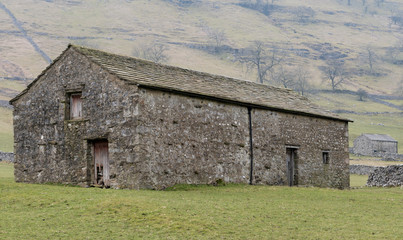 Fototapeta na wymiar Traditional stone barn on the dales Way footpath in the Yorkshire Dales National Park, near Kettlewell, Yorkshire, England, UK. 