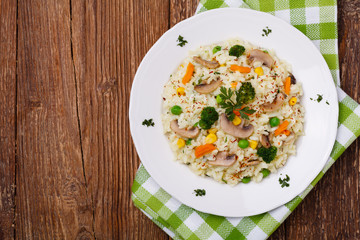 Classic Risotto with mushrooms and vegetables served on a white