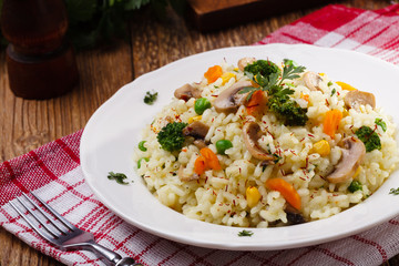 Classic Risotto with mushrooms and vegetables served on a white