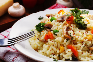 Classic Risotto with mushrooms and vegetables served on a white