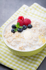 Oatmeal porridge in bowl with berries raspberries and blackberri