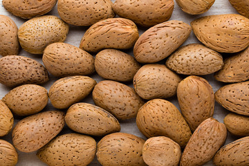 Group of almond nuts with leaves.Wooden background.