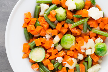 Fresh vegetables mix in a white bowl.