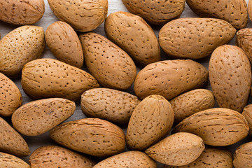 Group of almond nuts with leaves.Wooden background.