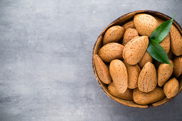 Group of almond nuts with leaves.Wooden background.