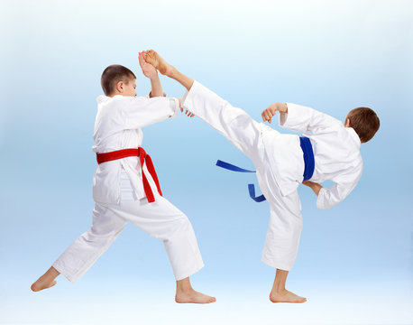 High kick and block are training boys in karategi
