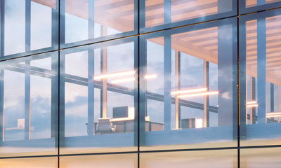Fototapeta na wymiar Closeup photo of modern business center.High floor office, interior in evening time. Panoramic windows facade background, contemporary building. Empty coworking room.Horizontal,flares. 3d rendering