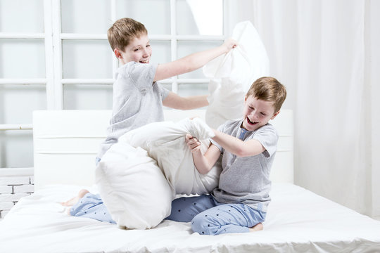 Young Children Playing On The Bed. Pillow Fight