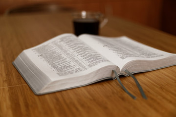 Fototapeta premium Bible on table. Holy Bible book on a background. The Holy bible on a wooden table. Christianity concept. Faith hope love concept. Christianity concept. Holy Bible background.. Faith hope love