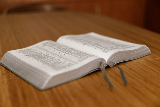 Bible on table. Holy Bible book on a background. Bible on old wood table. Beautiful dark background. Religious concept. The Holy Bible on a wooden table. Breakfast with the Holy Scriptures.