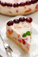 Cake with cherris, gelly yogurt and fruits. Isolated on white background. One piece in a white plate.