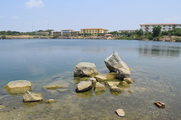 rocky pond with the building on the distance bank