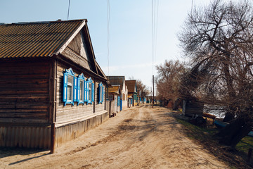 Street in the village with wooden houses along the road © kkolosov