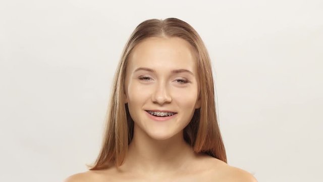 Young girl shows her smile braces. White