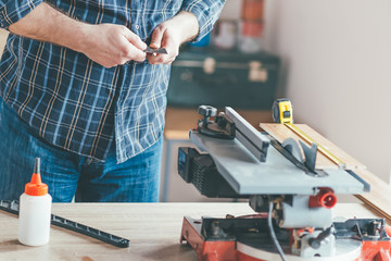 Carpenter sharp wooden pen in his workshop.