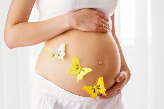 Pregnant woman with butterflies on her tummy