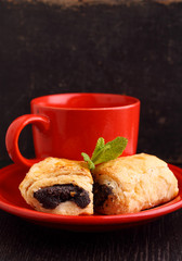 bun with poppy seeds, a cup of red on a black background