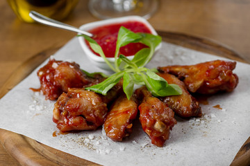 baked chicken legs with tomato sauce on a wooden board
