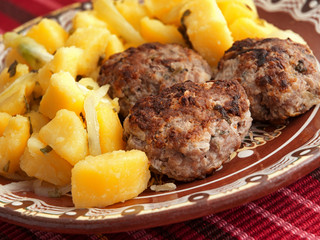 Pork and beef fried meatballs with potatoes salad. Close up
