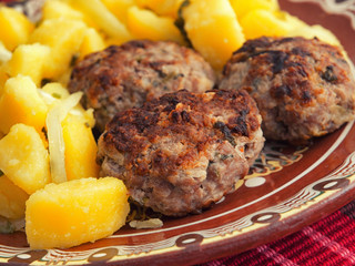 Pork and beef fried meatballs with potatoes salad. Close up horizontal shot shot