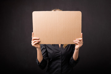 Woman hiding behind empty cardboard