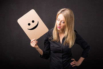 Woman holding cardboard with smiley