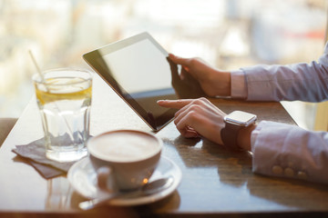 Woman with smart watch working on tablet