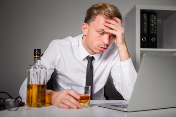 Tired man drinking at the office
