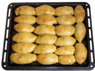 The metal baking sheet with rosy baked pies