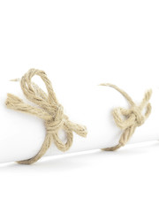 Handmade natural rope bows tied on white paper roll isolated