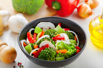 Salad in a bowl made of steamed broccoli, onion, mushroom, carrot and pepper.  Healthy vegetarian food.