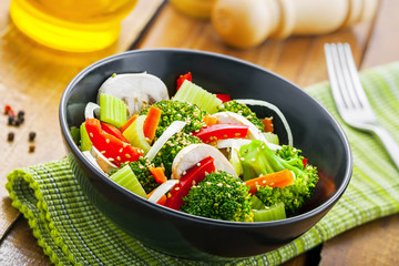 Salad in a bowl made of broccoli, onion, mushroom, carrot and pepper. Healthy vegetarian food.