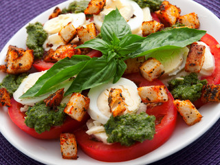Healthy salad with tomatoes, boiled eggs, pesto and croutons. Close up, horizontal view