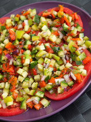Tomatoes with salsa salad made of cucumbers, peppers and onions