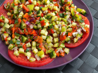 Tomatoes with salsa salad made of cucumbers, peppers and onions. Horizontal shot