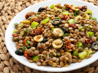 Lentil salad with green peppers, dried tomatoes and olives. Horizontal shot