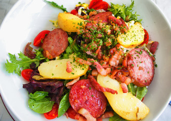 Gourmet salad with vegetables and fried ham served in a small beach restaurant in Cannes, France. Shot from above