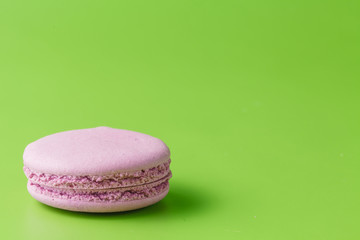 One macaroon on green background