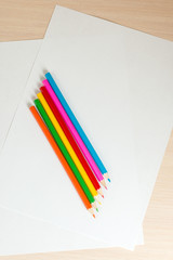 colored pencils to draw lying on a blank sheet of paper