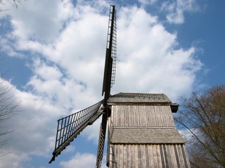 Alte Bockwindmühle aus dem 17. Jahrhundert aus grauem Holz bei Sonnenschein im Bauernhausmuseum im...