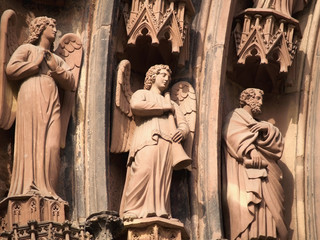 Close up of three statues engraved on Strasbourg cathedral.