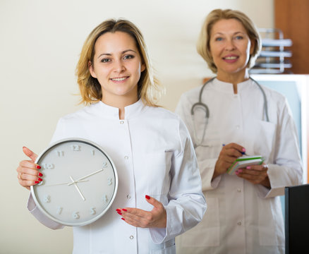 Two Female Doctors Showing Time In Clock