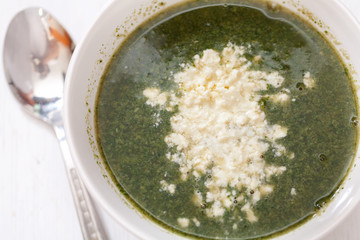Spinach soup with feta cheese and eggs, shot from above. Horizontal shot