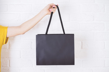 Hand holding shopping bag