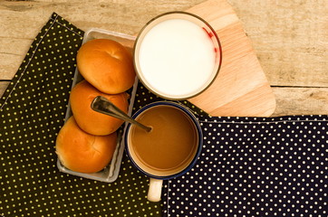breakfast with bread coffee and milk on table background.