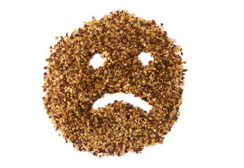 A pile of crushed red pepper flakes with a sad face drawn in it. Use to depict Indigestion,...