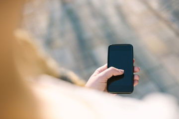 girl with smartphone outdoors in park. Closeup of female hands a