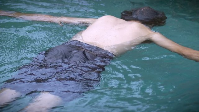 Man floating face down in a pool Medium shot